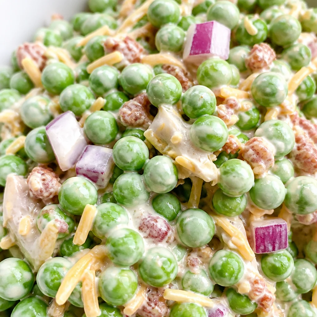 Creamy Green Pea Salad with cheddar, bacon, and red onions served in a bowl.